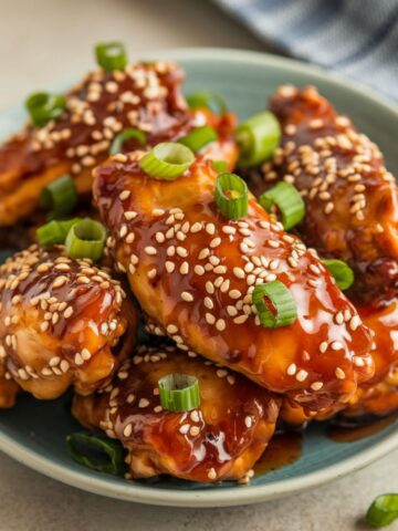 Juicy Bang Bang Chicken wings glazed in a sweet and spicy sauce, garnished with sesame seeds and fresh green onions, perfect for any occasion.