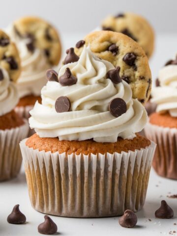 Chocolate chip cupcakes topped with rich vanilla frosting, garnished with chocolate chips and mini cookies, perfect for a delightful Chocolate Chip Cupcakes Recipe.