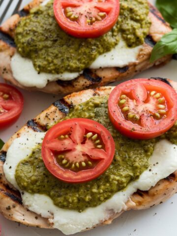 Grilled Chicken Margherita recipe featuring juicy grilled chicken breast topped with creamy mozzarella, fresh basil pesto, and ripe tomato slices. A healthy and delicious dinner option bursting with Italian-inspired flavors.