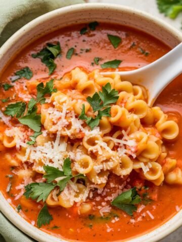 A hearty and flavorful pastina soup recipe featuring tender pasta in a rich tomato broth, topped with Parmesan cheese and fresh parsley. Perfect for a cozy and comforting dinner.