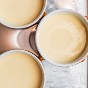 Three cake pans filled with smooth and creamy batter, ready to be baked into the Tom Cruise Coconut Cake. The rich, velvety texture of the batter ensures a moist and fluffy coconut-flavored cake, perfect for layering with decadent frosting.