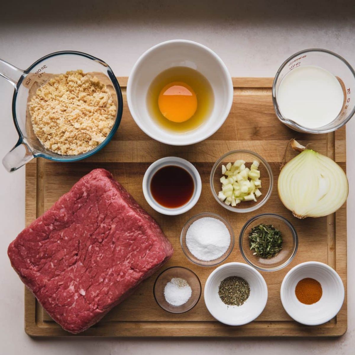 Fresh ingredients for a One Pound Meatloaf Recipe, including ground beef, breadcrumbs, egg, milk, onions, Worcestershire sauce, and spices. This classic homemade meatloaf is tender, juicy, and packed with savory flavors for the perfect comfort food dinner.