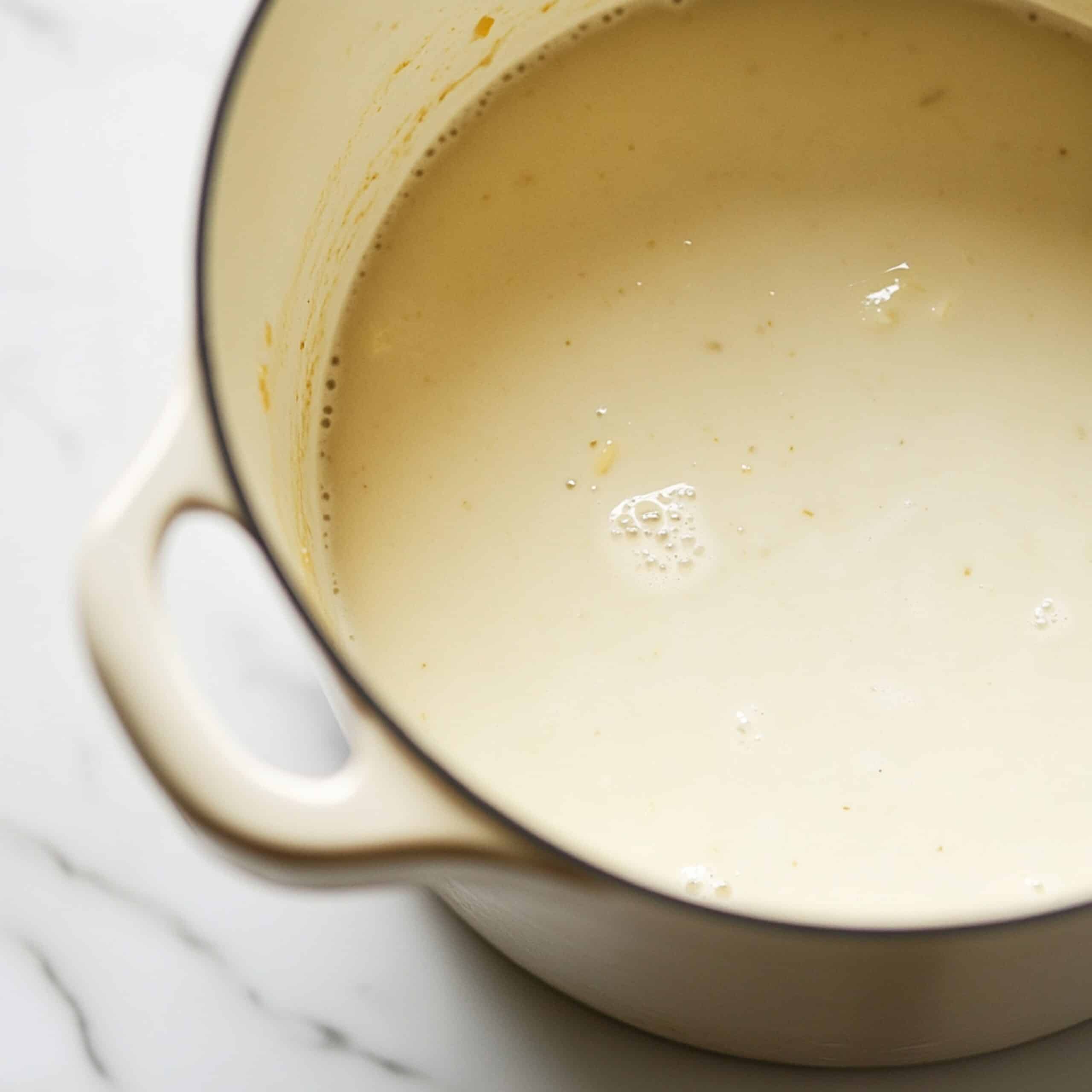 Creamy soup broth forming in pot