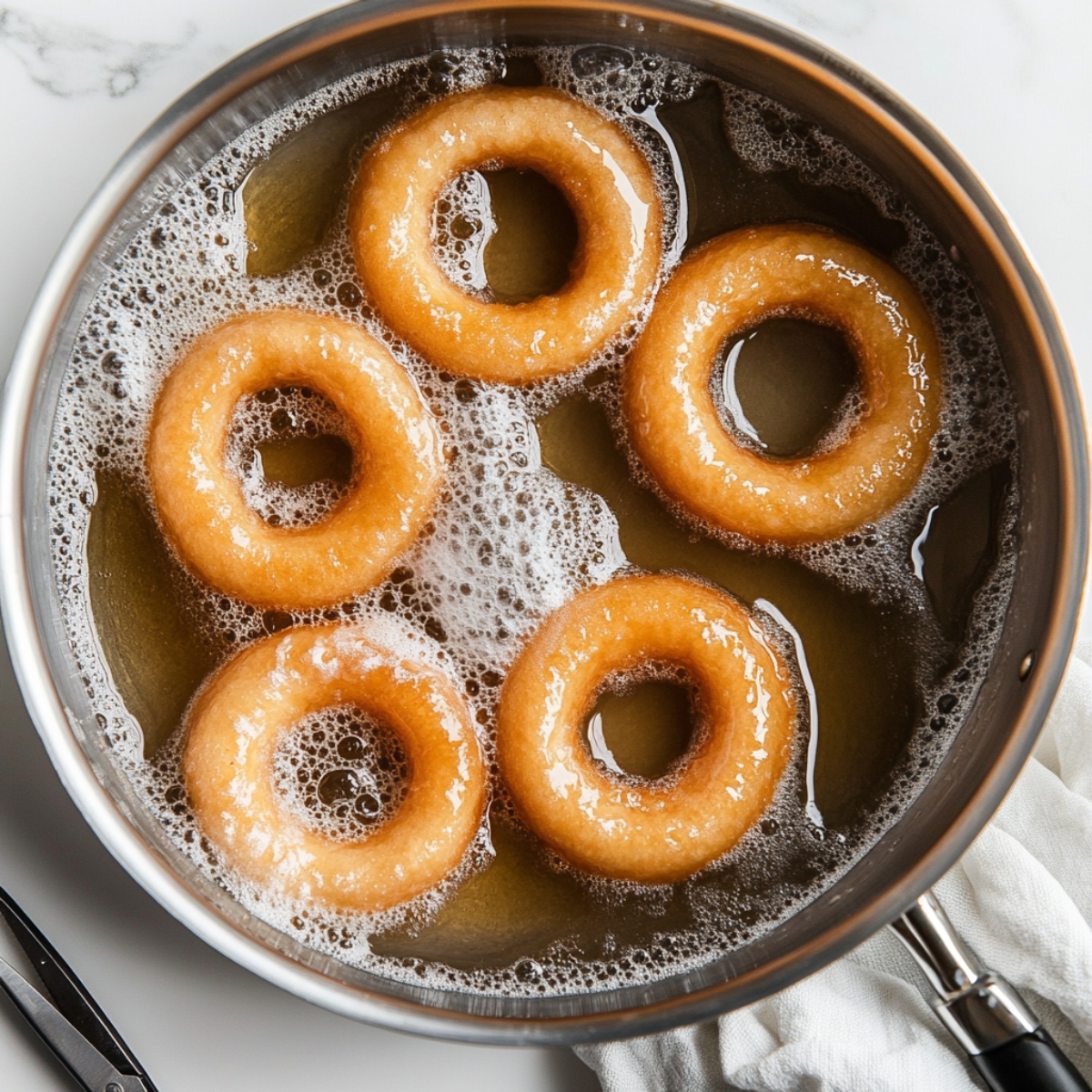 Churro donut rings frying in hot oil on stovetop