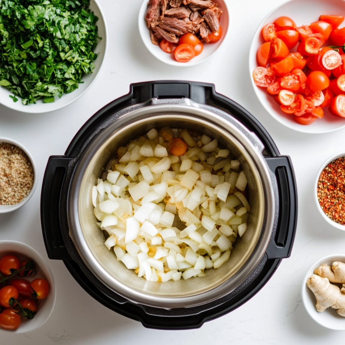 Golden onions and spices beside Instant Pot ready to cook curry.