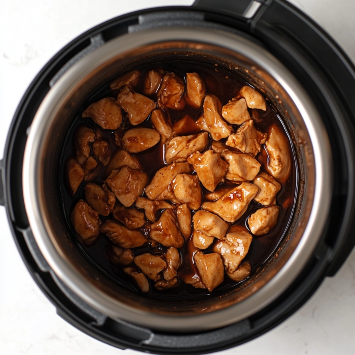  Instant Pot filled with uncooked chicken and teriyaki sauce just before pressure cooking.