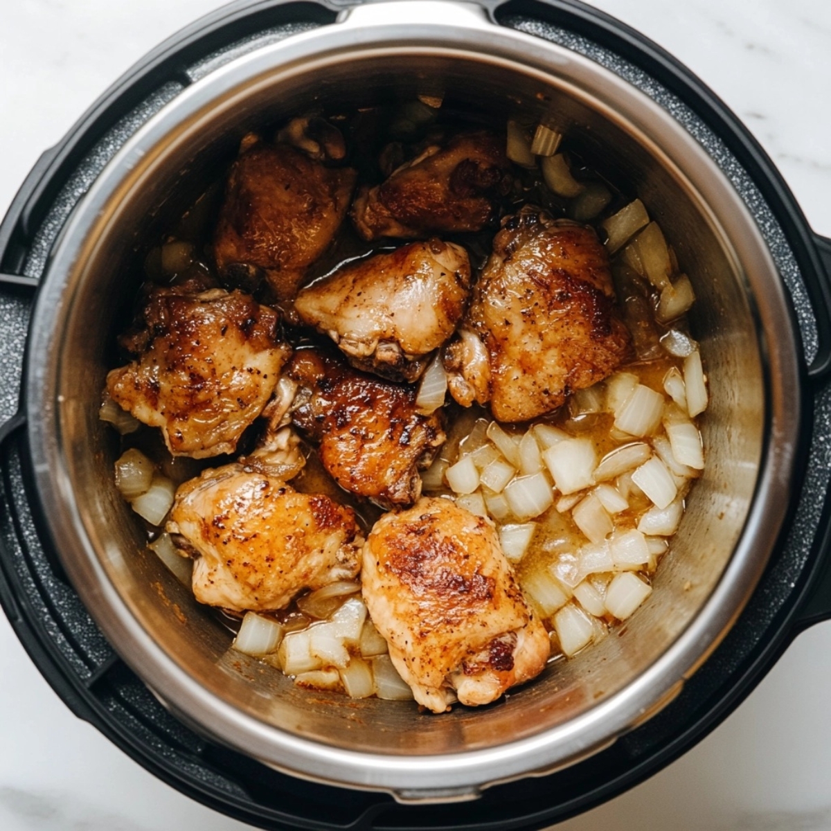 Browning Greek chicken thighs with onions and garlic in Instant Pot