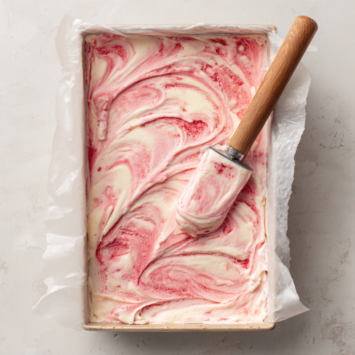 Strawberry swirled vanilla ice cream in pan before freezing