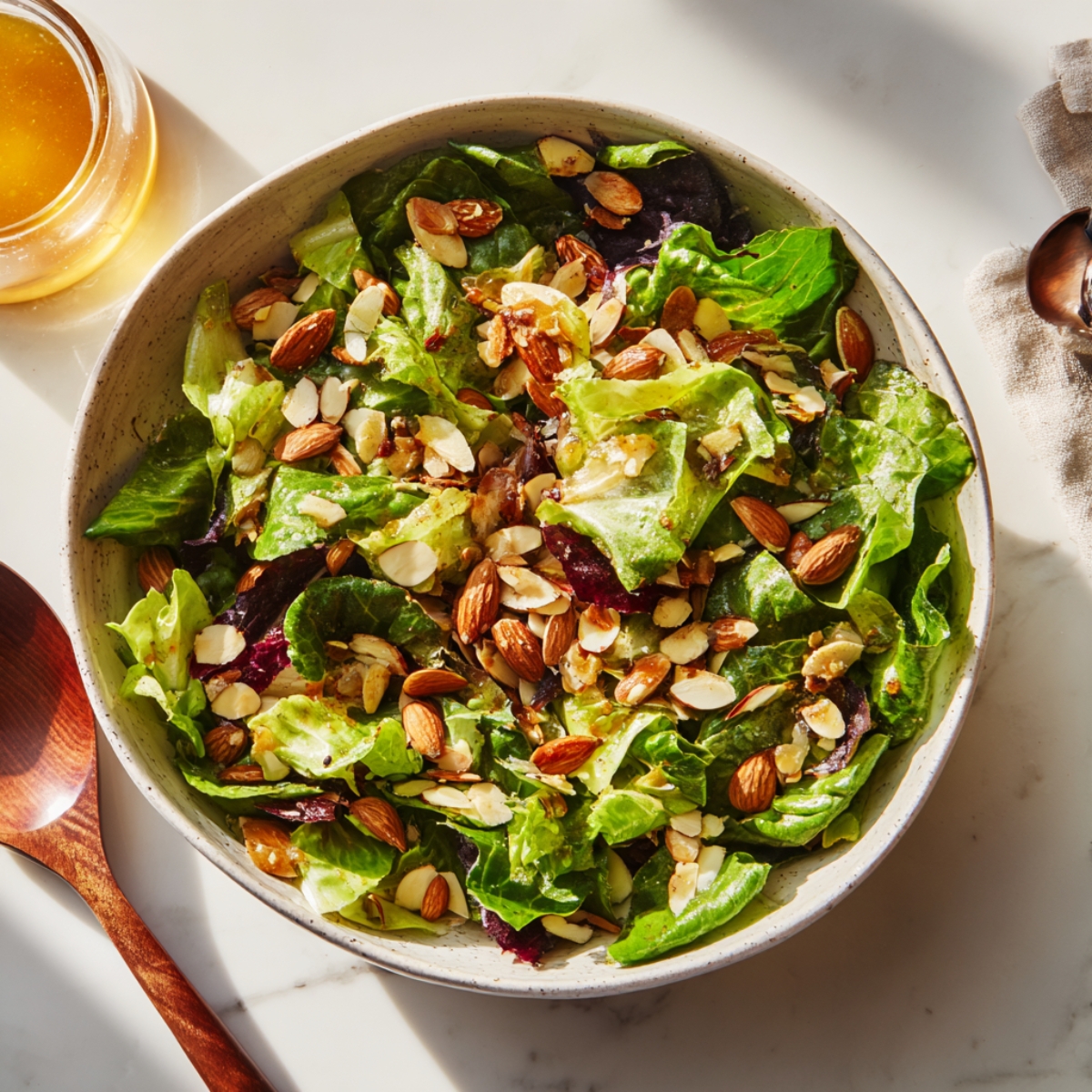 Finished sunshine salad with dressing and almonds on top

