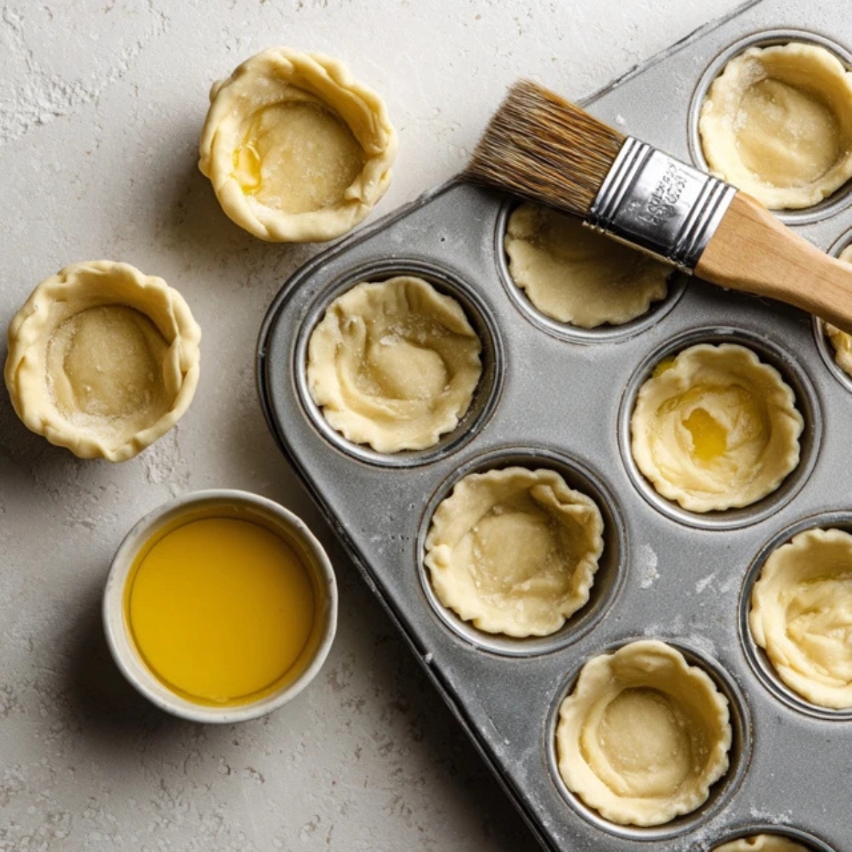 Mini muffin tin filled with crescent dough on white counter