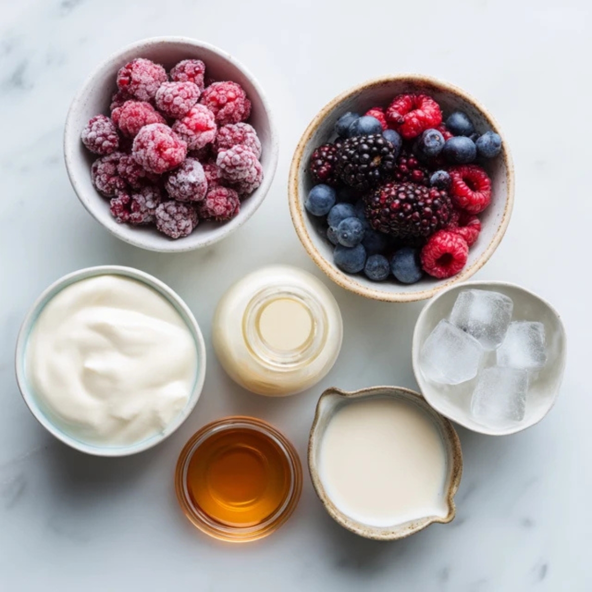 ogurt, berries, almond milk, and ingredients on a white kitchen counter