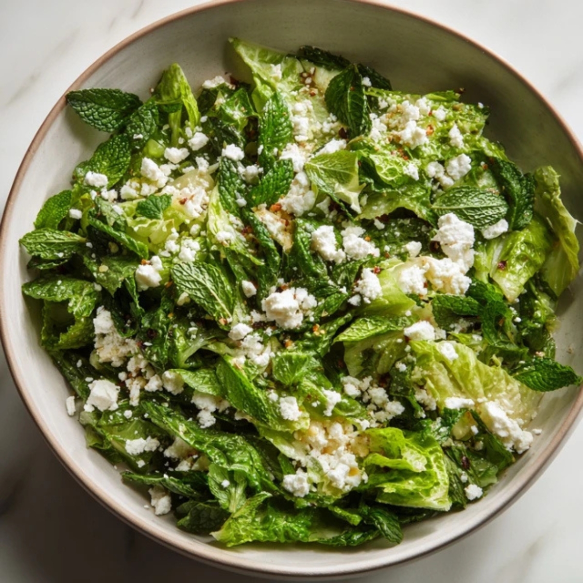 Finished cucumber strawberry salad with feta and mint on top.