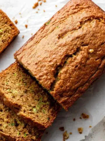 Moist gluten free zucchini bread with slices on white counter
