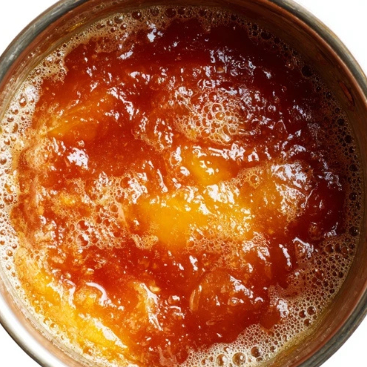 Thickened nectarine jam in a pot with golden hue

