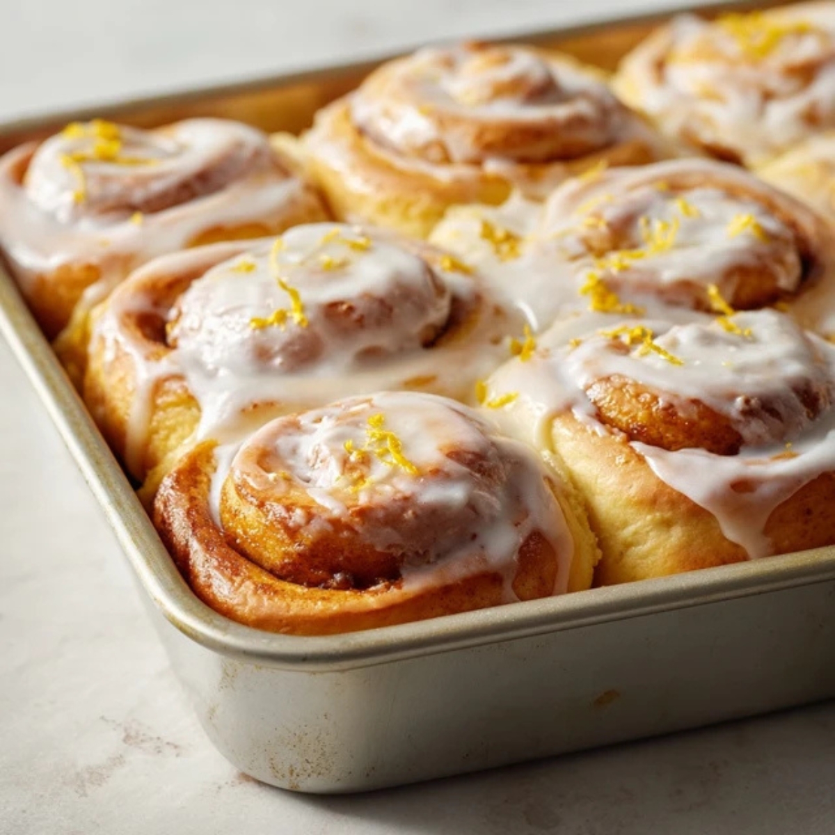 Freshly baked lemon sweet rolls topped with lemon cream cheese frosting

