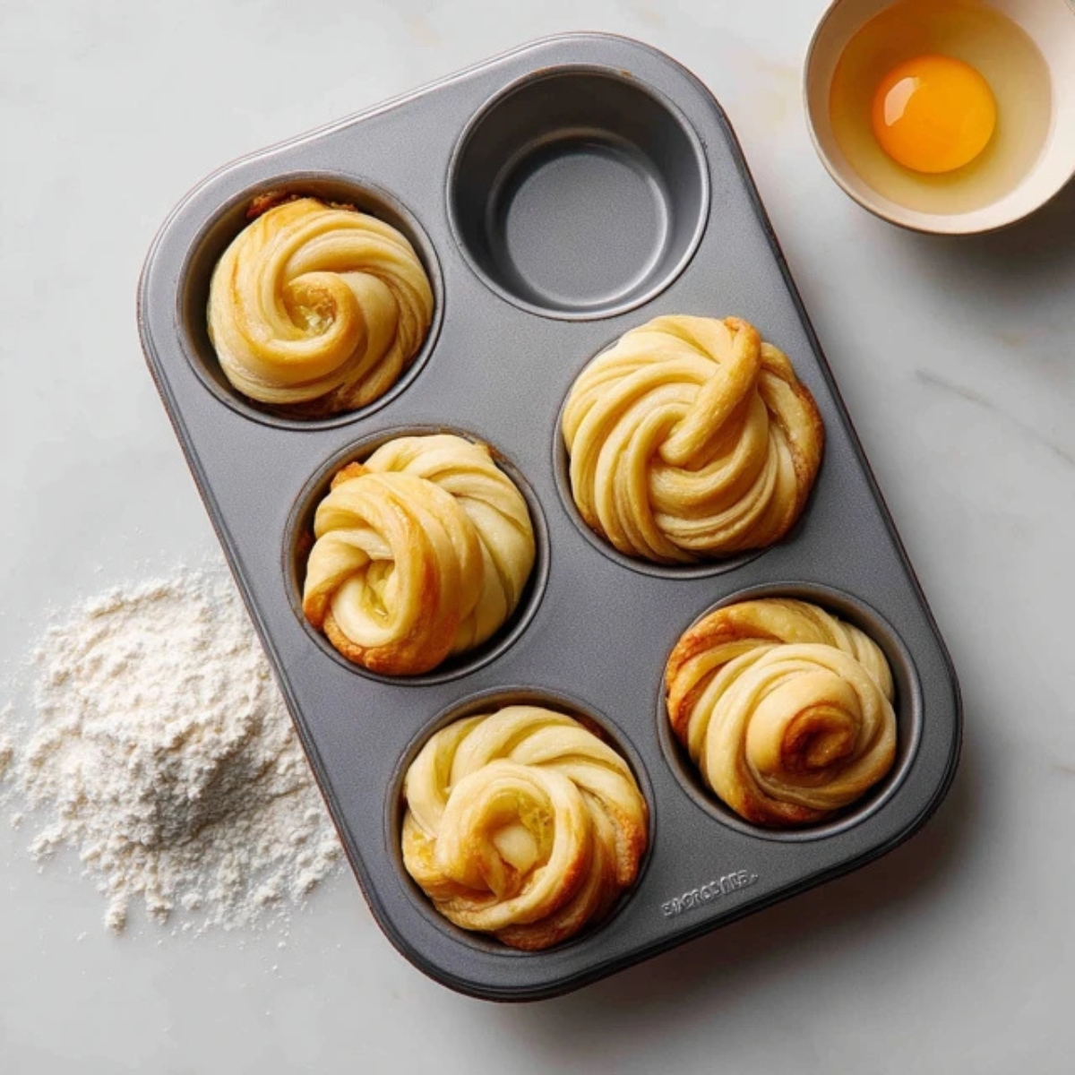 Cruffin dough spirals placed in muffin tin