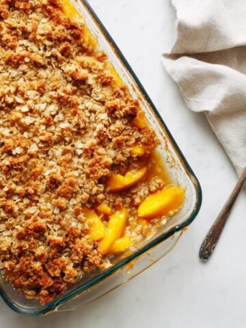 Rustic nectarine crisp with golden oat topping in glass dish