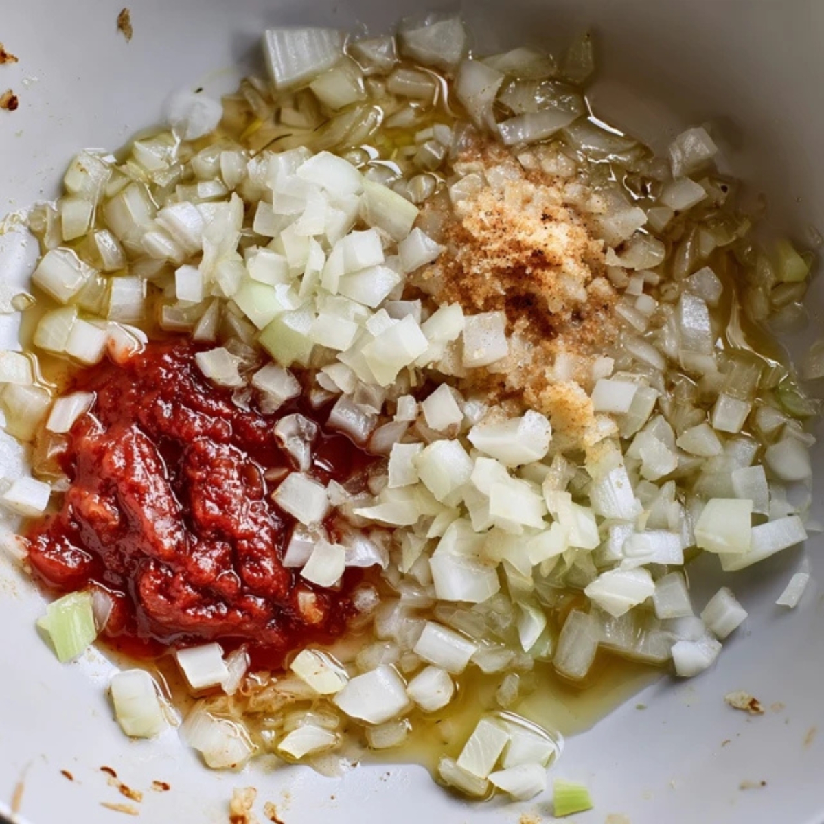 Sautéed onions, garlic, and tomato paste in pan