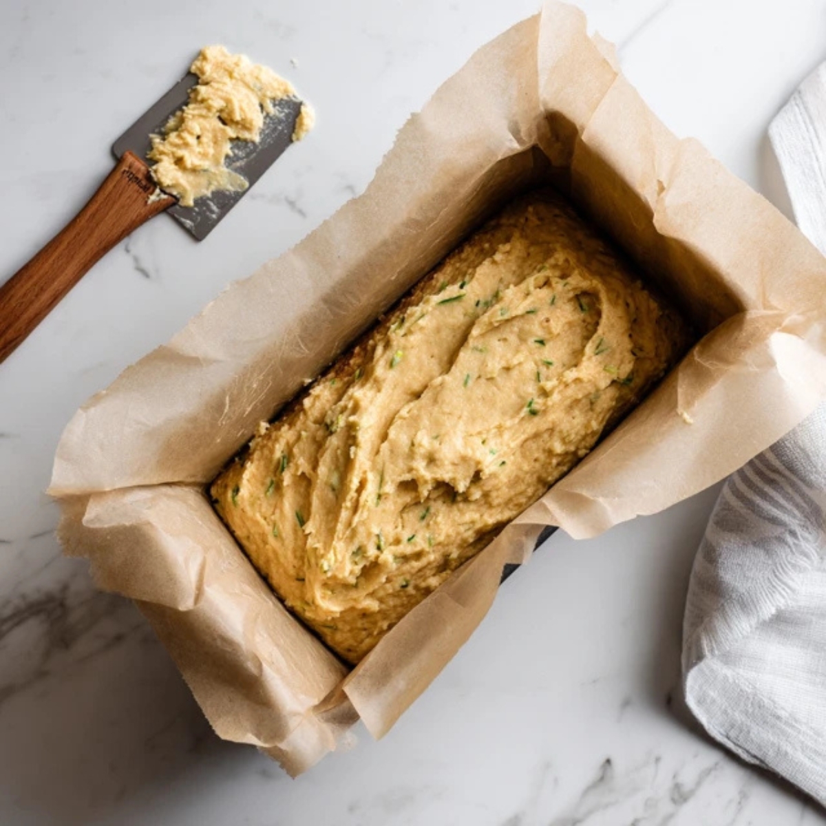 Unbaked keto zucchini bread batter in loaf pan on counter