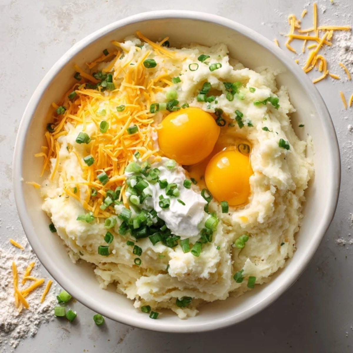 Mixing mashed potatoes, cheese, and eggs in bowl for cheese puffs