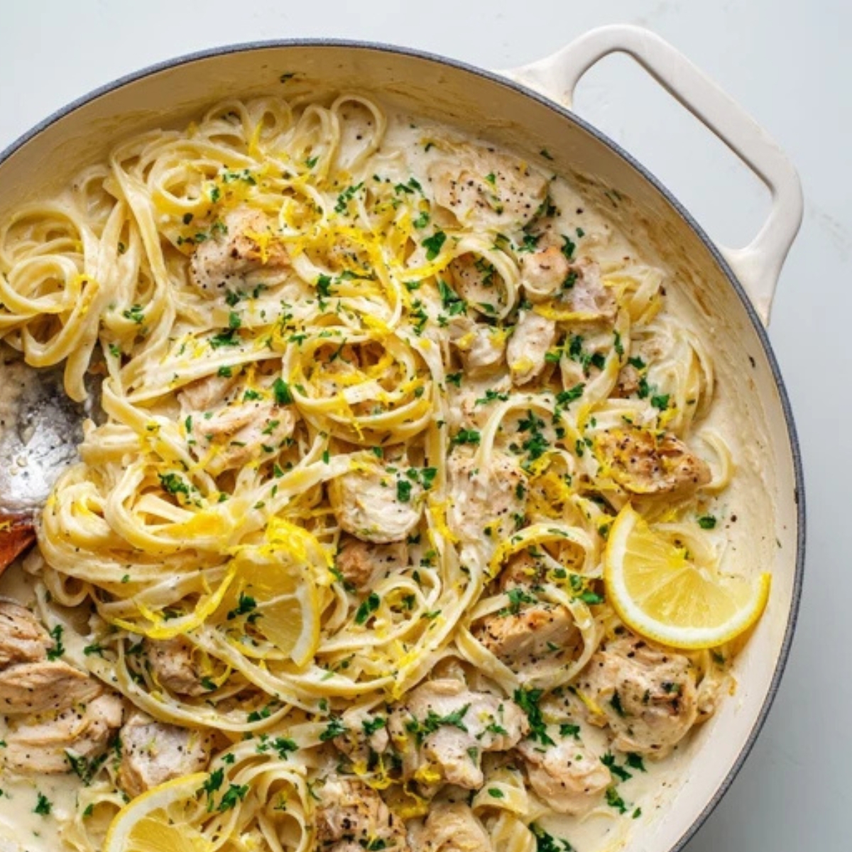 creamy lemon garlic sauce in pan with chicken and pasta