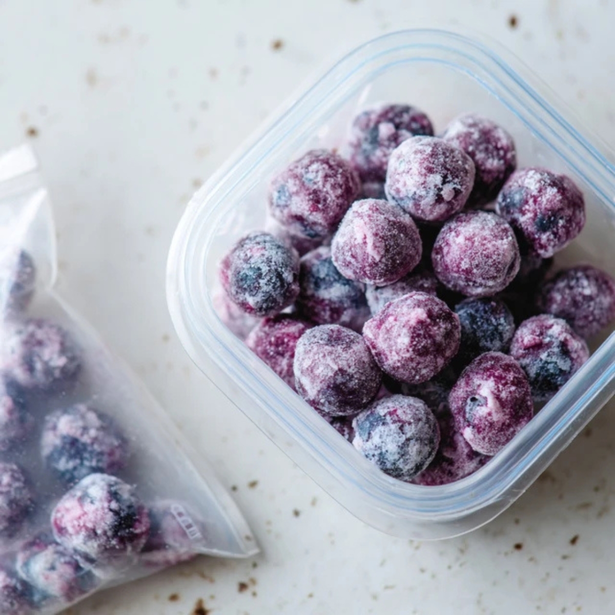 Frozen blueberry yogurt bites stored in a container on a kitchen counter