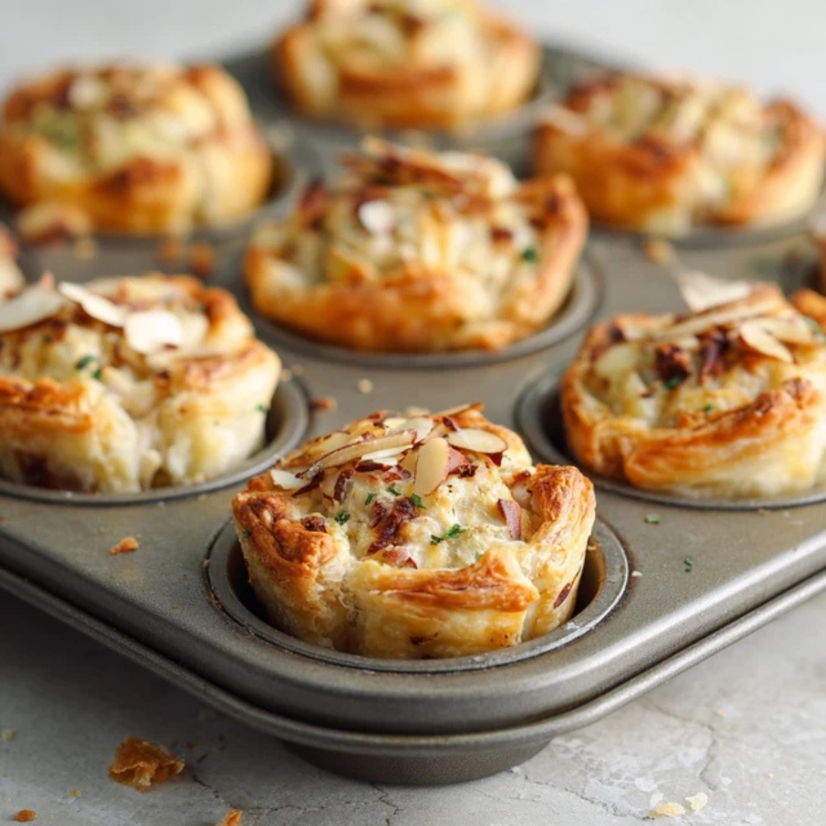 Golden baked chicken salad puffs cooling in muffin tin

