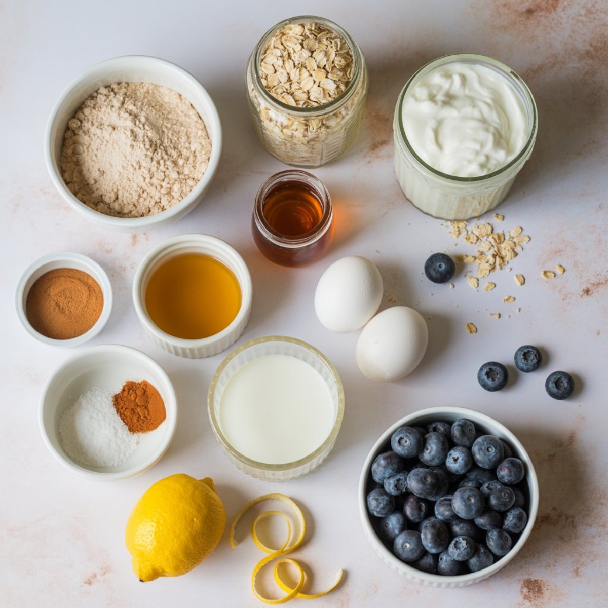 flat lay of blueberry protein muffin ingredients on white counter