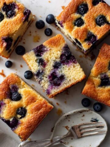 Homemade blueberry yogurt cake sliced on white counter