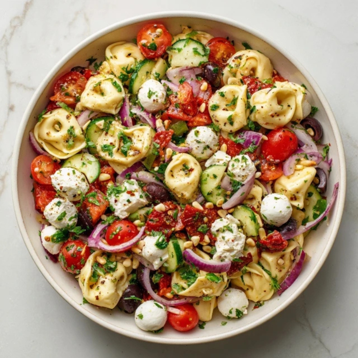Cheese tortellini pasta salad with fresh veggies and Italian dressing in a bowl