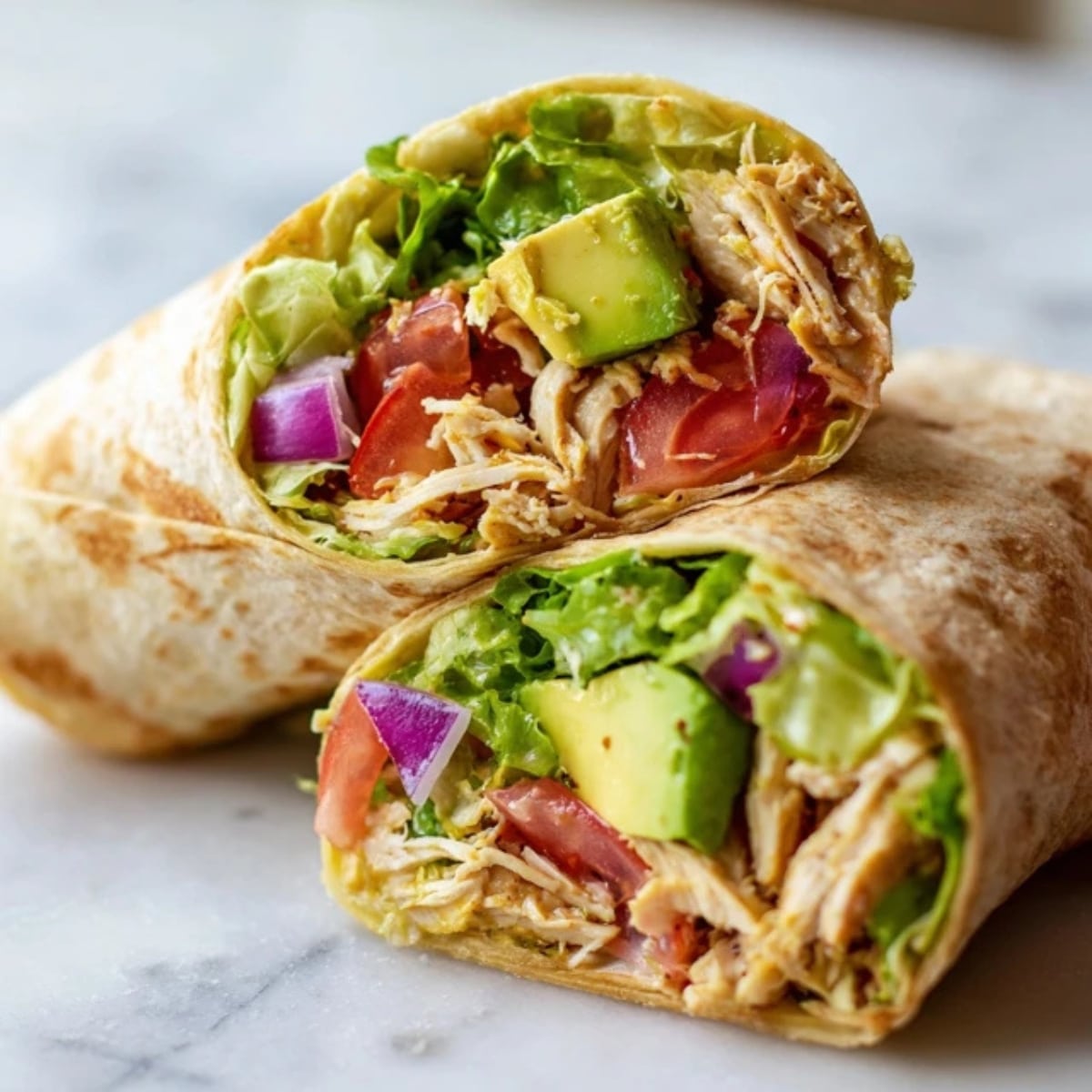 fresh chicken avocado wraps cut in half on counter
