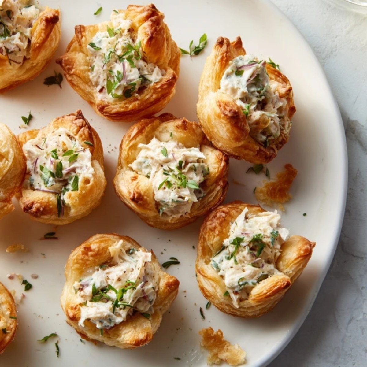 Golden chicken salad puffs pastries on white plate

