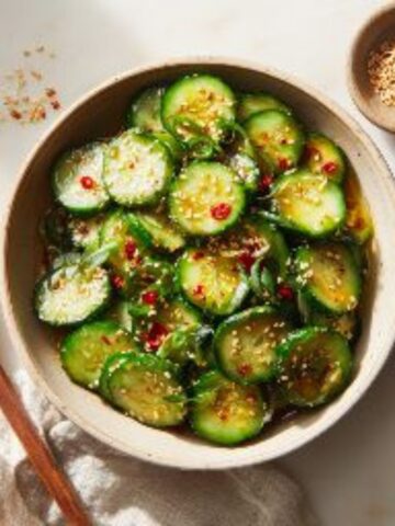 cucumber sesame salad in ceramic bowl on white counter