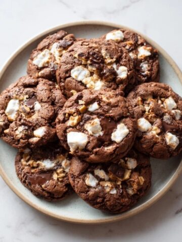gooey rocky road cookies with marshmallows and nuts on plate