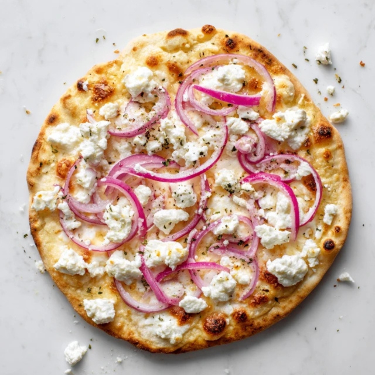 Pizza dough topped with mozzarella, goat cheese, and red onion slices.