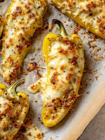 golden baked stuffed banana peppers on baking sheet