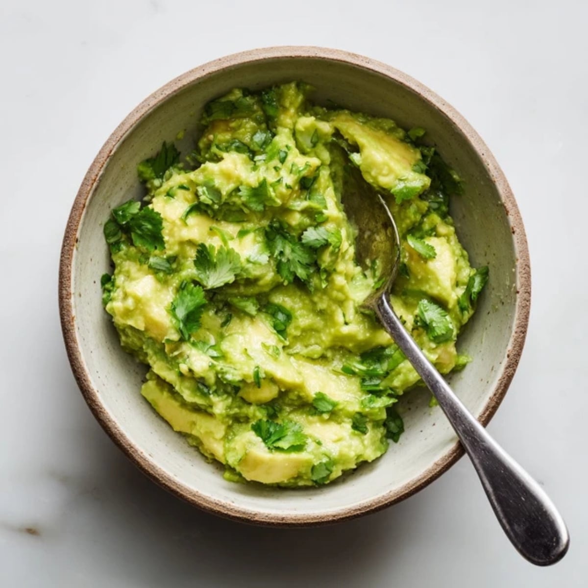 mashed avocado with lime and yogurt in small bowl