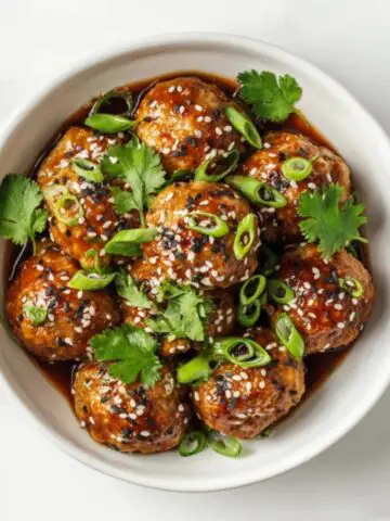 Sticky Asian turkey meatballs with soy glaze in white bowl