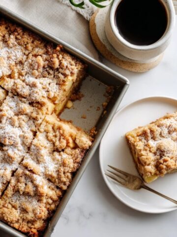 Homemade apple crumb cake with golden buttery topping on white kitchen counter