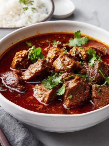 Authentic beef vindaloo curry with rice on white counter