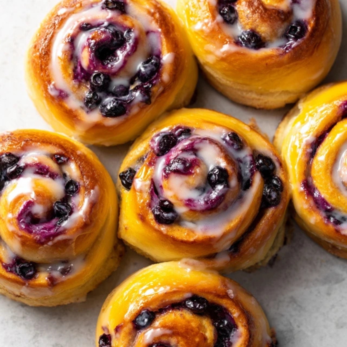 Homemade blueberry sweet rolls with lemon glaze on kitchen counter
