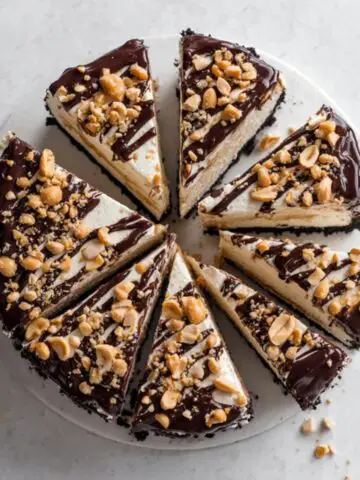 Homemade buster bar ice cream cake with Oreo crust, peanut butter, vanilla ice cream, and chocolate ganache.