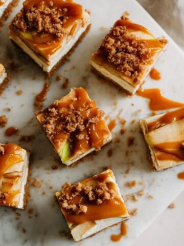 homemade caramel apple cheesecake bars with caramel drizzle