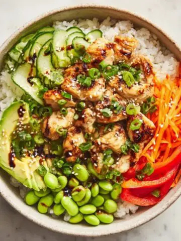 Chicken rice bowl with colorful vegetables and sesame soy sauce