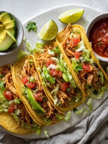 juicy shredded chicken tacos instant pot on tortillas with fresh toppings