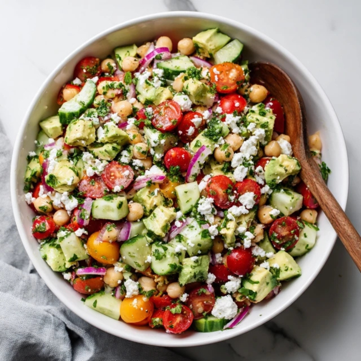 Mediterranean chickpea feta avocado salad in a white bowl