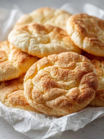 Fluffy golden cloud bread rounds on parchment paper
