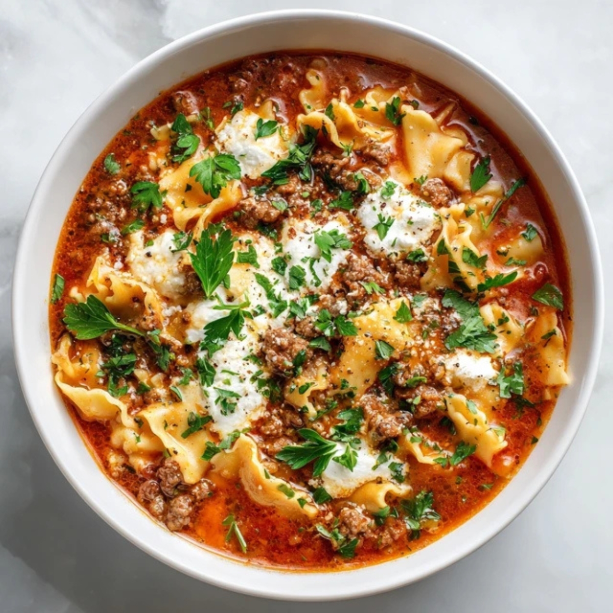 Crockpot lasagna soup with beef, noodles, and melted cheese