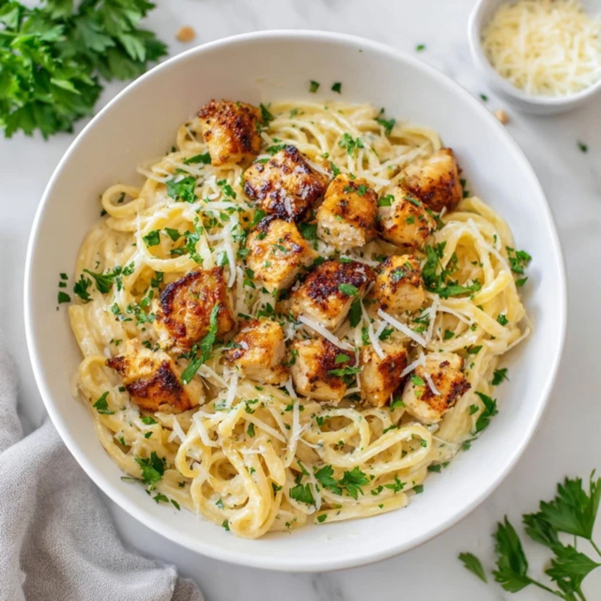 Garlic butter chicken bites with creamy parmesan pasta in white bowl