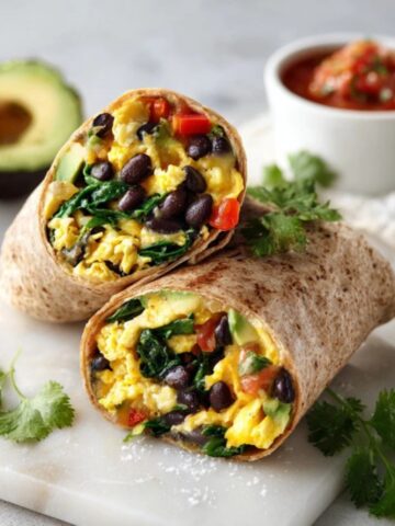 Healthy breakfast burrito with eggs, beans, avocado, and veggies